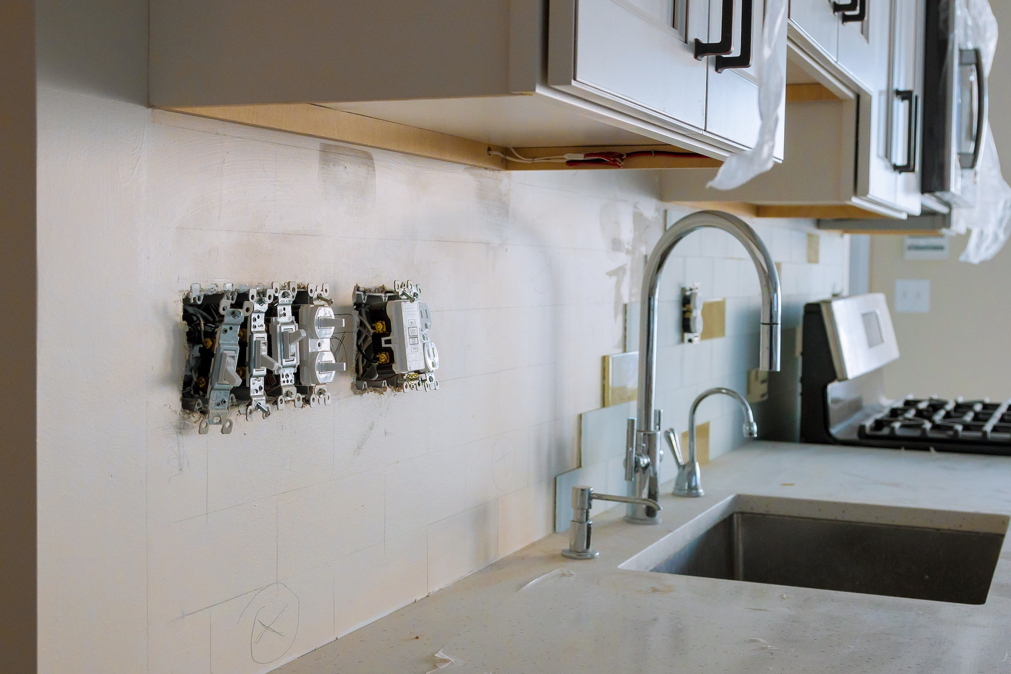 Work on installing electrical outlets with electrical wires and connector installed in kitchen